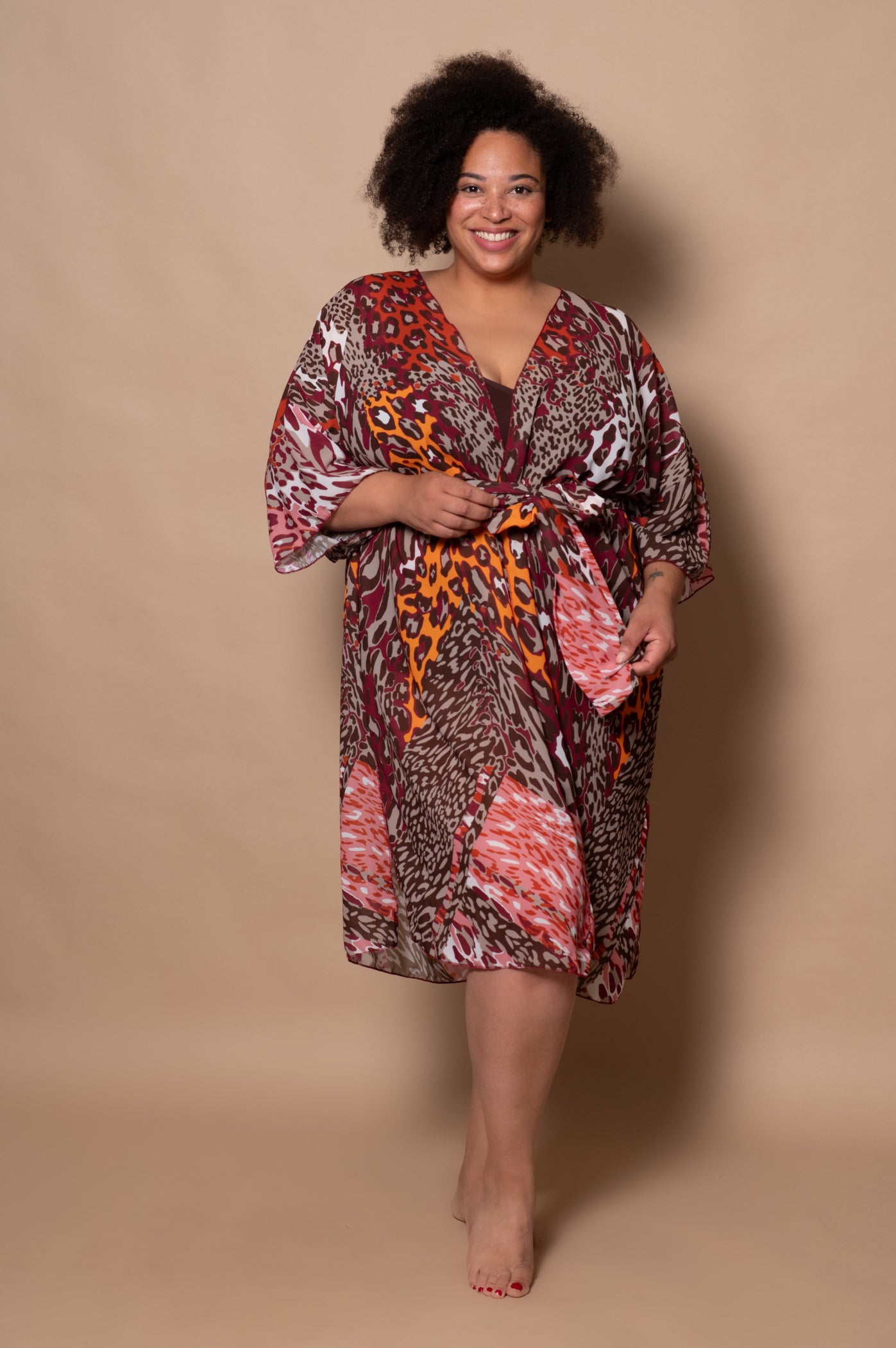 Woman wearing a patterned dress against a beige background
