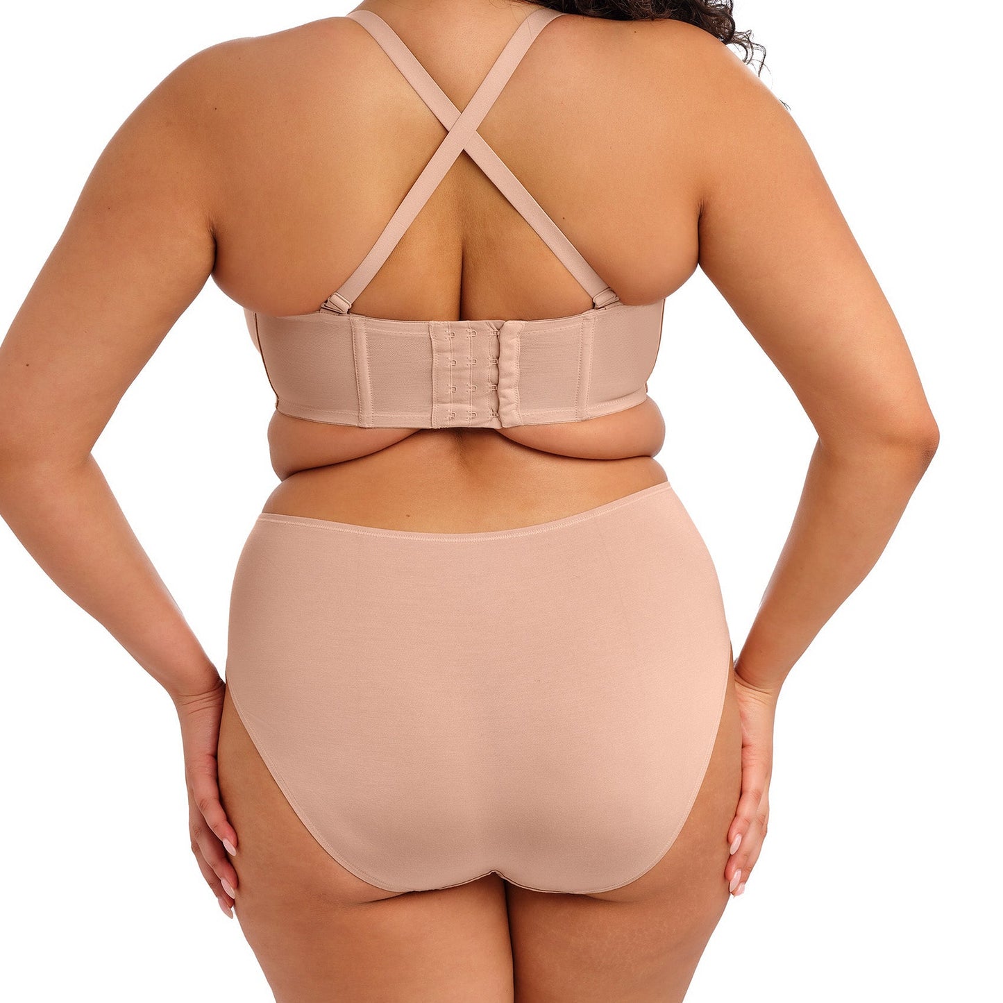 curvy woman wearing nude color smooth lingerie briefs against a white background