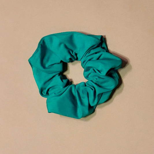 emerald green scrunchie on a beige background