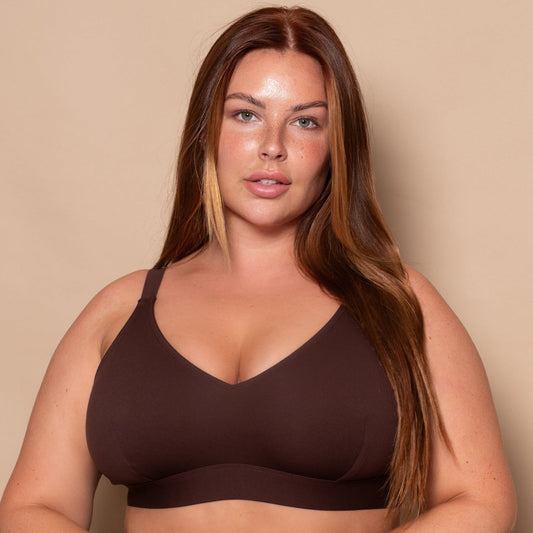 plussize woman wearing a chocolate brown bikini set against a beige background