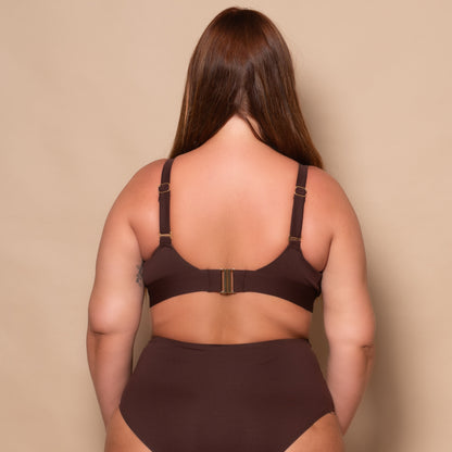 plussize woman wearing a chocolate brown bikini set against a beige background