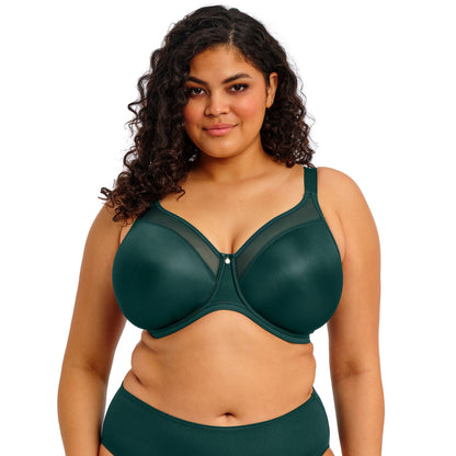 curvy woman wearing an emerald green lingerie set against a white background