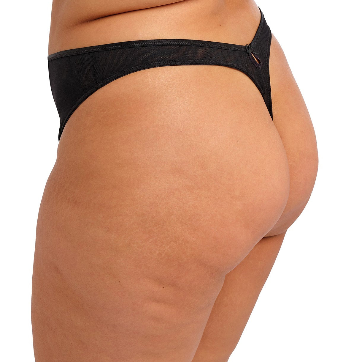 curvy woman wearing a black thong with lace and embroidered flowers in summer colours