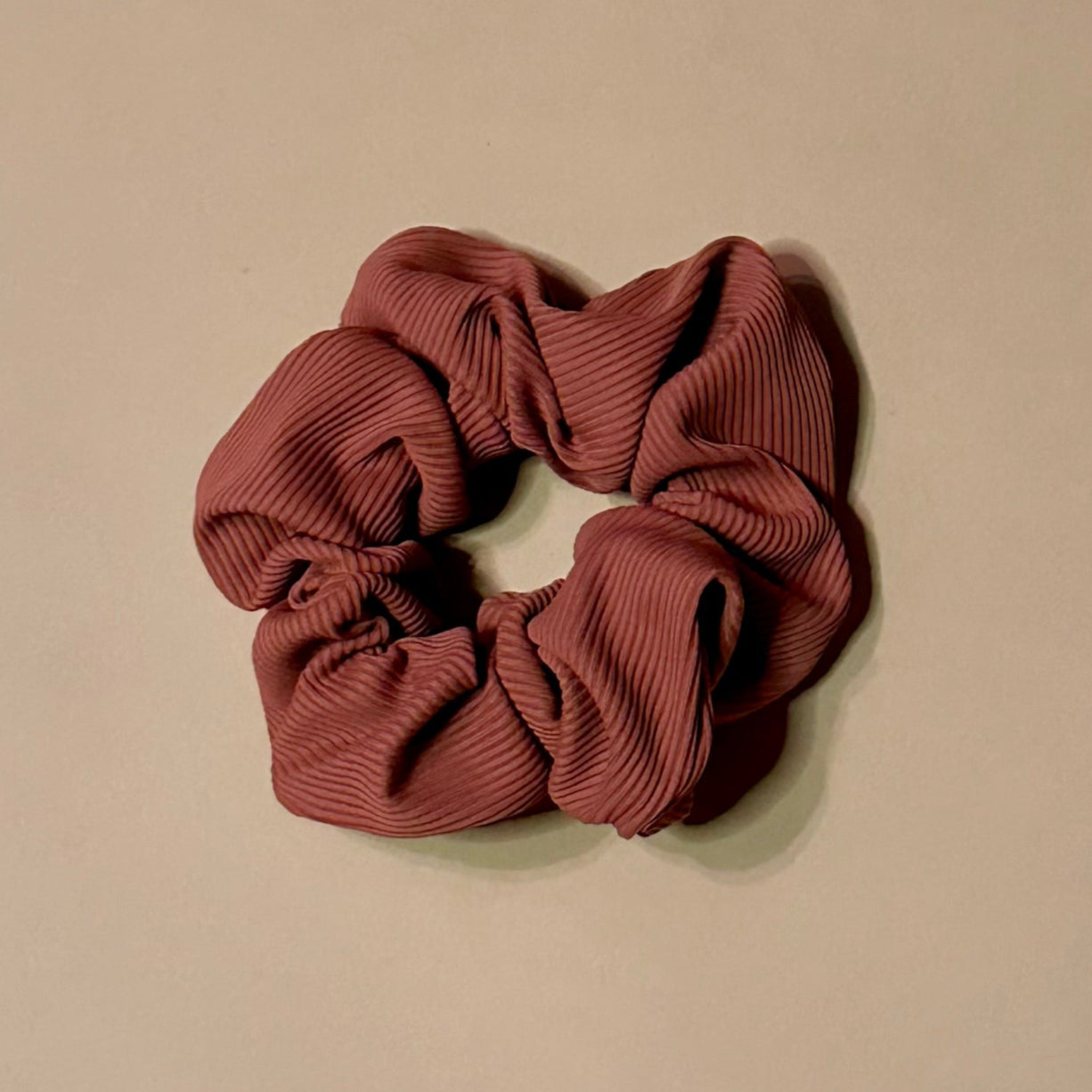 pink rosewood ribbed scrunchie on a beige background