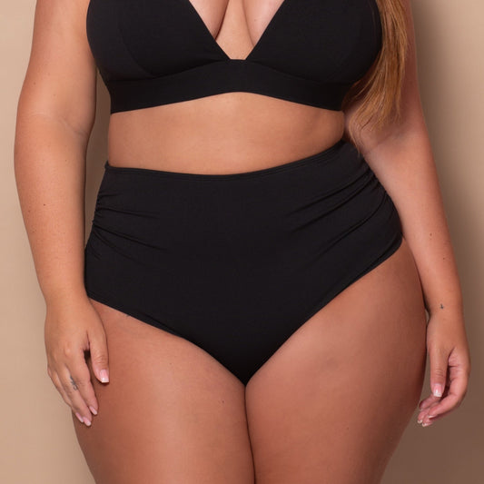 curvy woman wearing a black bikini against a beige background