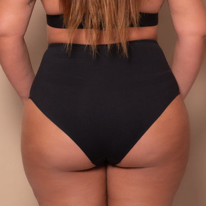 curvy woman wearing a black bikini against a beige background