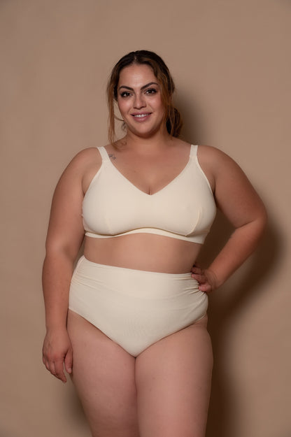 plussize woman wearing a white cream bikini  against a beige background