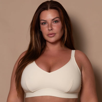 plussize woman wearing a cream white bikini  against a beige background
