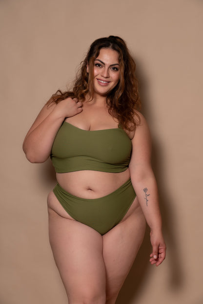 plussize woman wearing a green khaki bikini set against a beige background