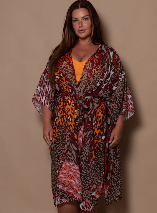 curvy woman wearing a patterned dress against a beige background