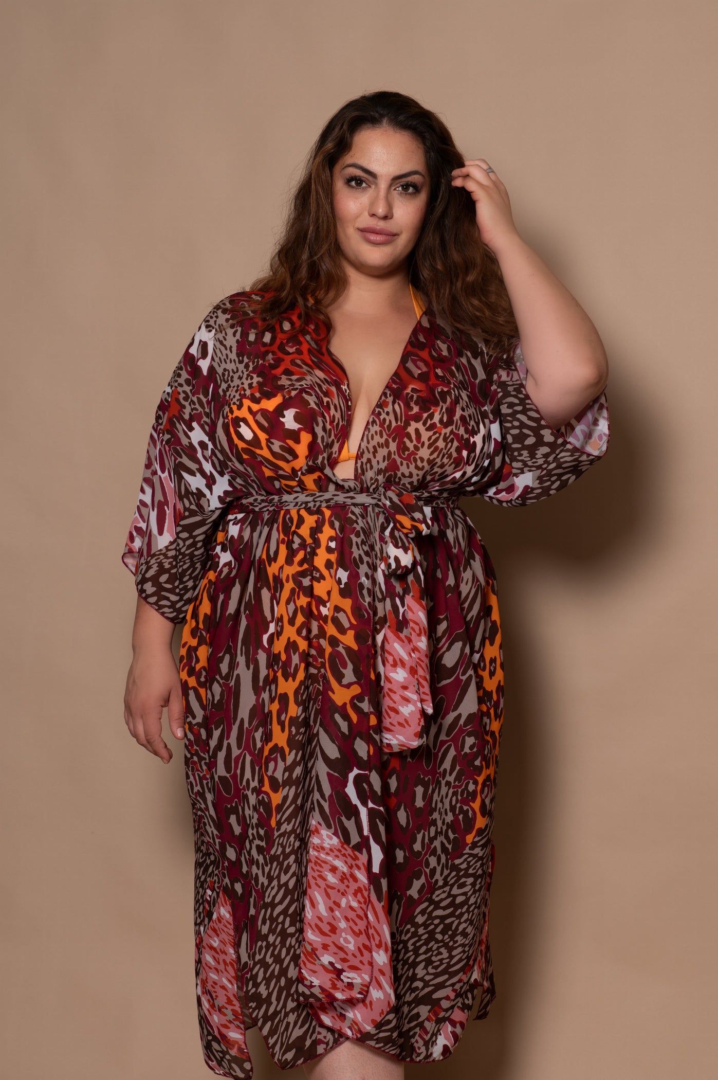 plussize woman wearing a patterned dress against a beige background