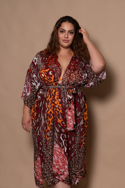 plussize woman wearing a patterned dress against a beige background