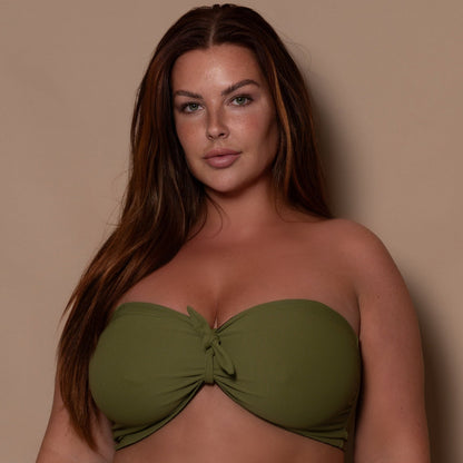 plussize woman wearing a khaki green bikini  against a beige background