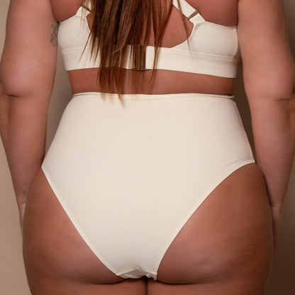 plussize woman wearing a cream white high waist bikini  against a beige background