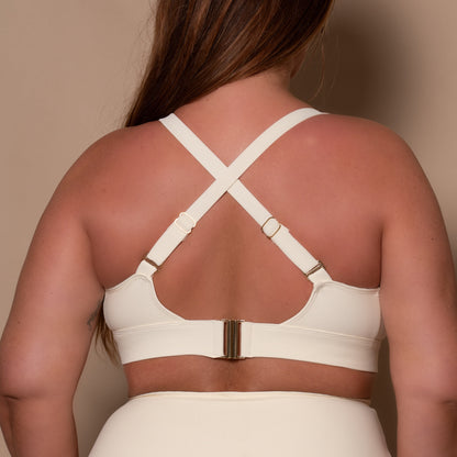 plussize woman wearing a cream white bikini  against a beige background