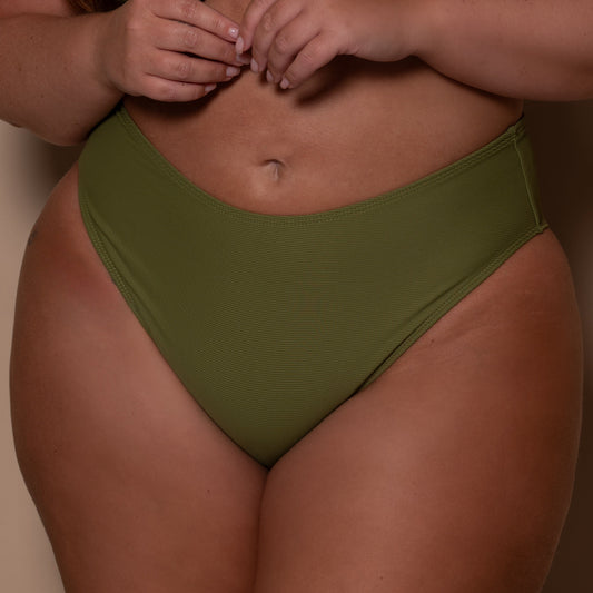 plussize woman wearing a khaki green bikini  against a beige background