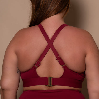 plussize woman wearing a pomegranate red bikini  against a beige background