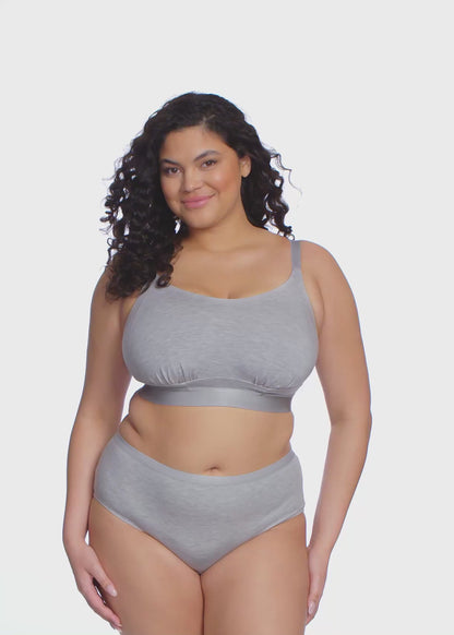 Curvy woman wearing a grey bra and underwear set against a white background