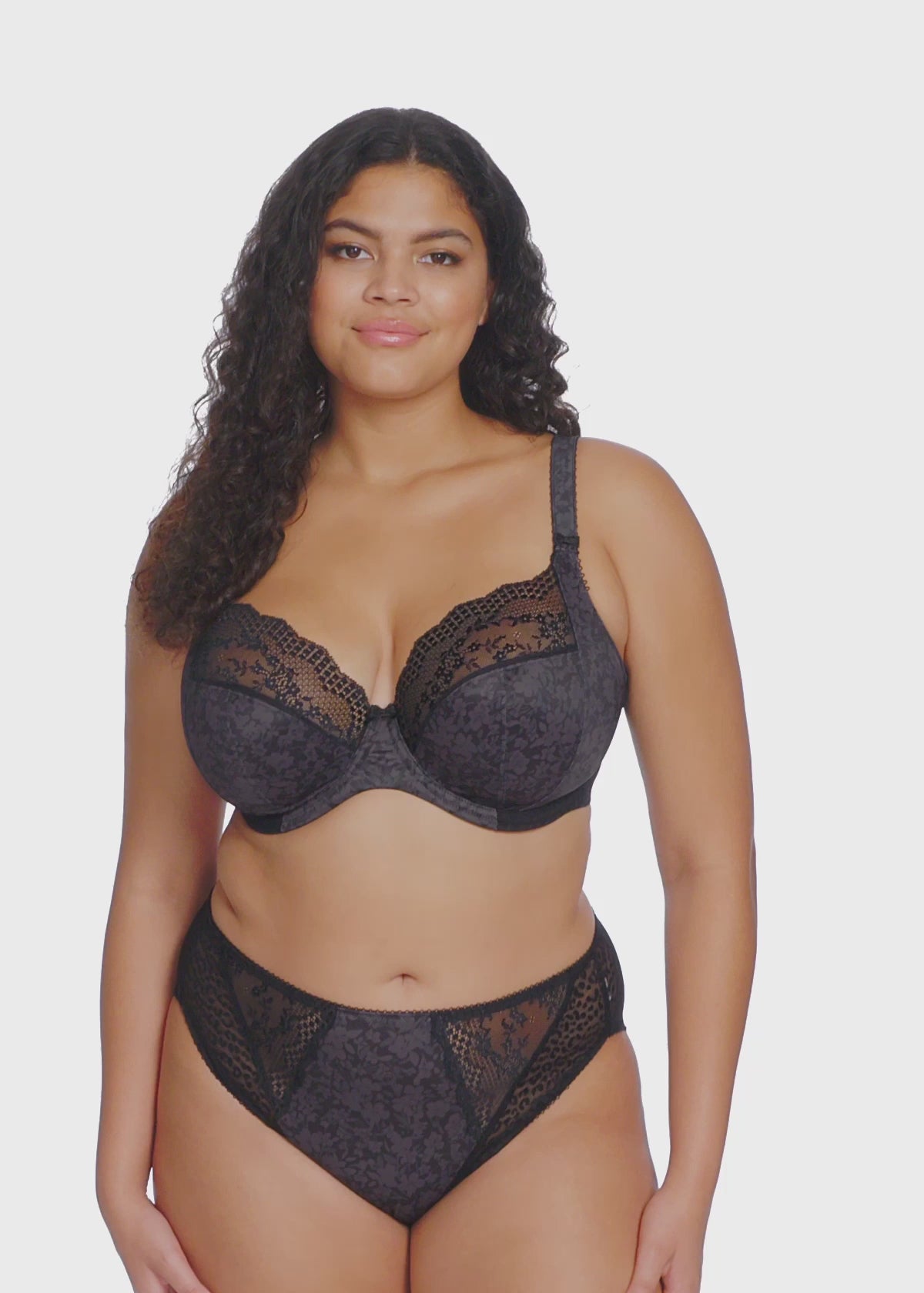 curvy Woman wearing a black lace lingerie set on a white background