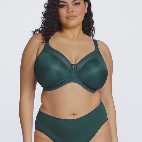 curvy woman wearing an emerald green lingerie set against a white background