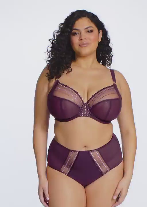 curvy woman wearing purple lingerie against a white background